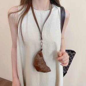 Gros plan détaillé d'une mini pochette croissant marron avec des ferrures métalliques