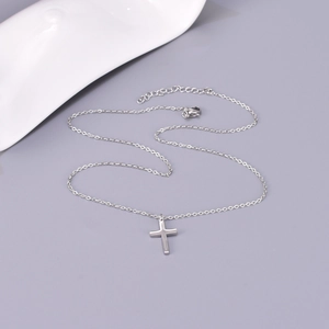 Vue macro d'un collier pendentif croix minimaliste en argent avec chaîne réglable
