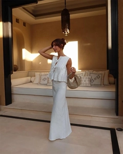 Detailed view of white two-piece linen set featuring sleeveless crop top and high-waist skirt