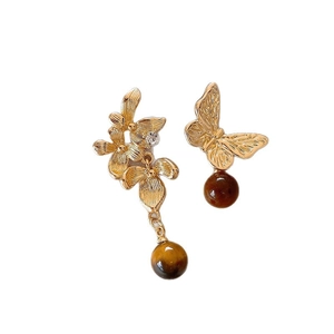 Asymmetric flower and butterfly earrings with brown tiger eye beads on white background