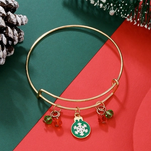 Detail of adjustable gold Christmas bracelet with green snowflake charms and festive decor