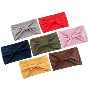 Flat lay of 7 colorful knotted headbands in soft knit fabric for yoga and sports