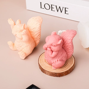 Cute squirrel shaped aromatherapy candle in peach and pink colors on wooden base