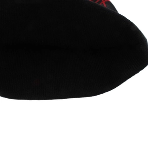 Close-up of black knitted beanie fabric texture with distinctive red stitching details
