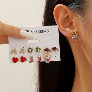 Close-up of Christmas stud earrings set featuring reindeer and snowman enamel charms