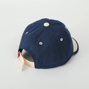 Close-up of navy blue kids baseball cap showing white daisy embroidery and adjustable strap