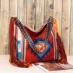 Close-up of bohemian woven tote featuring ethnic patterns and long decorative fringes