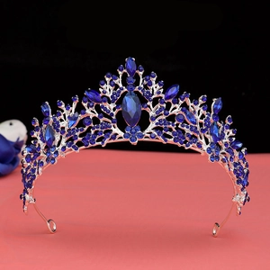 Macro detail of Baroque silver crown featuring deep blue crystal floral vine patterns