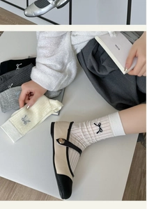 Close-up of thin cotton ballet socks with delicate bow embroidery and rib knit texture
