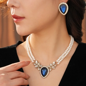 Détail du collier de perles à double rang et boucles d'oreilles avec pierres bleues