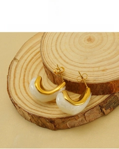 Close-up of gold-plated C-shaped earrings with white resin and 18K vacuum plating detail