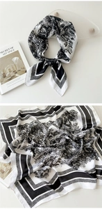 Detailed macro view of black and white Toile de Jouy silk scarf with satin texture finish