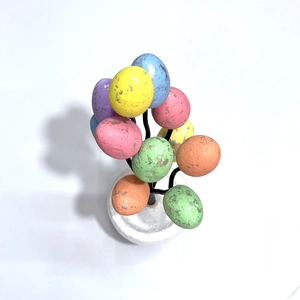 Colorful Easter egg tree bonsai with speckled foam eggs on a white decorative base