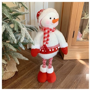 Detail of a plush Christmas snowman with telescopic striped legs and a red hat