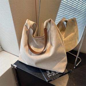 Minimalist beige suede tote bag with brown leather handles for stylish daily commuting