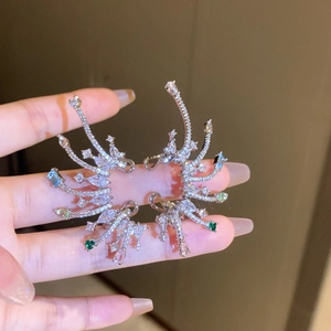 Détail de la manchette d'oreille en forme d'aile avec pierres de zircone émeraude et saphir