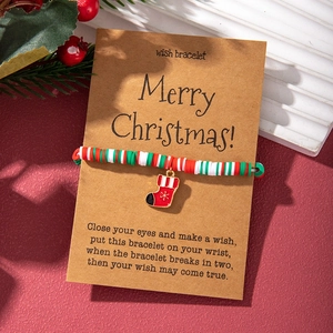 Christmas polymer clay beaded bracelet with a red stocking charm on festive card packaging