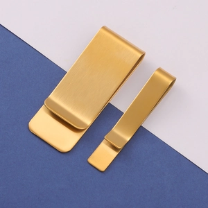 Macro view of brushed gold metal money clip and tie bar set showing fine texture details