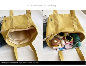 Detail view of yellow canvas tote bag showing large capacity and internal zipper pocket