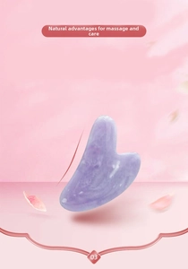 Macro shot of heart-shaped purple jade gua sha stone with smooth edges and natural texture