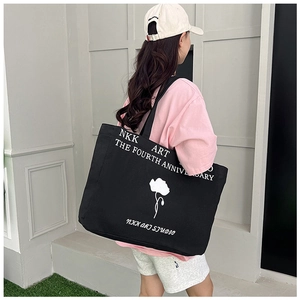 Black canvas tote bag showing the stylish over-the-shoulder look and large capacity
