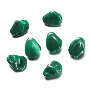 Close-up of green irregular acrylic beads with malachite patterns for DIY jewelry