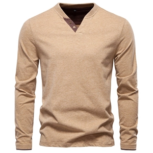 Close-up of the three-button Henley V-neckline on a khaki cotton long sleeve shirt