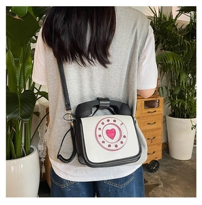 Close-up of a creative vintage telephone shaped crossbody bag in a lifestyle setting