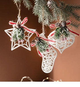 Detail of Christmas stocking, star, and heart ornaments with pine needles and berries