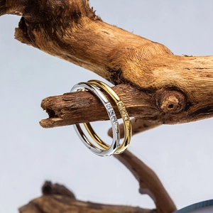 Detailed macro view of minimalist gold and silver slim rings with three inset zircons