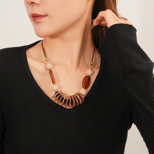 Close-up of bohemian layered necklace with brown leather and beads on model neck