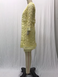 Détail d'un cardigan en dentelle jaune clair avec motifs floraux ajourés tricotés