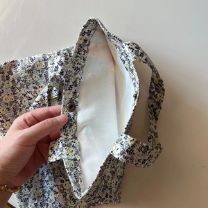 Detail of floral cotton tote bag showing vintage bronze magnetic closure and lining