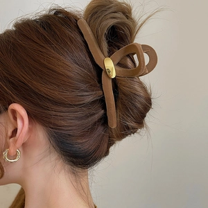 Pince à cheveux géométrique floquée marron sur un modèle avec une coiffure élégante