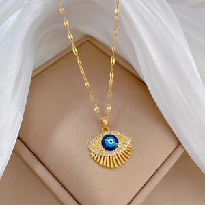 Elegant gold titanium steel necklace featuring a blue evil eye pendant with clear crystals