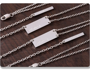 Macro shot of silver rectangle pendants with ChuDong engraving on O-chains