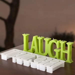 Detailed silicone mold and green scented candle in LAUGH alphabet letter design