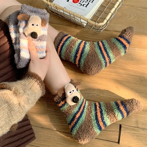 Detailed view of plush coral fleece socks featuring 3D cartoon dog doll ornaments