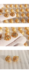 Macro shot of colorful enamel flower earrings with sparkling cubic zirconia on gold metal