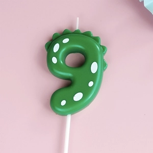 Green dinosaur number 9 birthday candle with white polka dots for party decoration