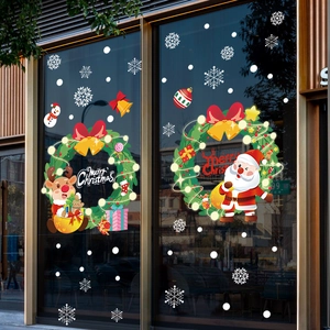 Adesivi natalizi con Babbo Natale, renna e ghirlanda su vetrina in vetro