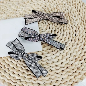 Macro shot of three sparkling rhinestone bow hair clips in silver, gold and iridescent colors