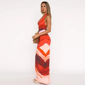 Side view of a sexy deep V-neck halter maxi dress with vibrant red and pink abstract prints