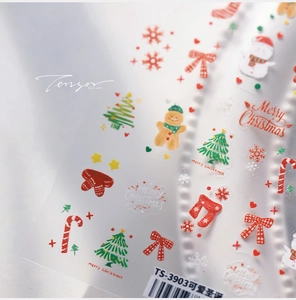 Macro shot of Christmas nail art stickers featuring gingerbread man and snowman details