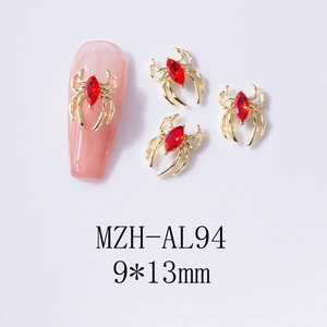 Detail of 9x13mm gold spider nail charm with marquise red rhinestone on pink manicure
