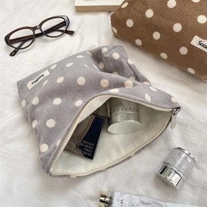 Detail of gray corduroy polka dot makeup bag with silver zipper and soft inner lining