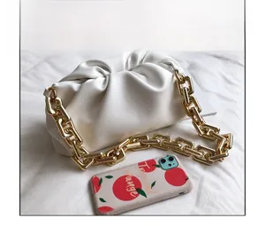 Size comparison of white pleated cloud bag with chunky gold chain shoulder strap