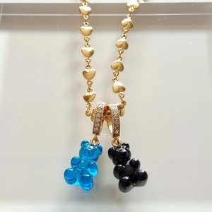 Detail of gold chain necklace with blue and black gummy bear crystal pendants
