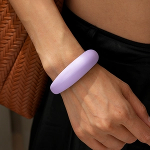 Nahaufnahme des minimalistischen matten lila Acryl-Armreifs am Handgelenk