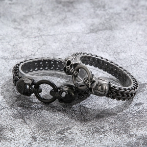 Close-up of punk skull bracelets in black and silver finishes on a display stand